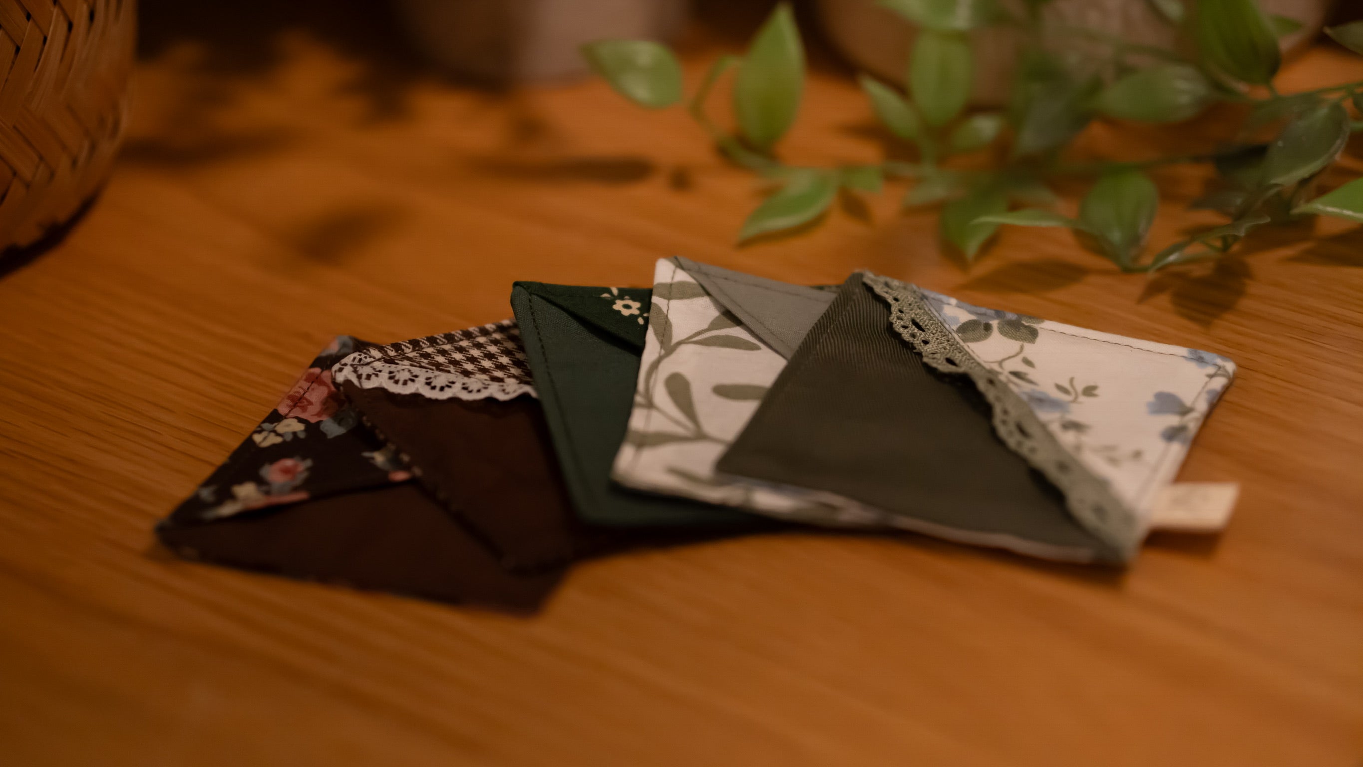A selection of square fabric bookmarks on a wooden surface