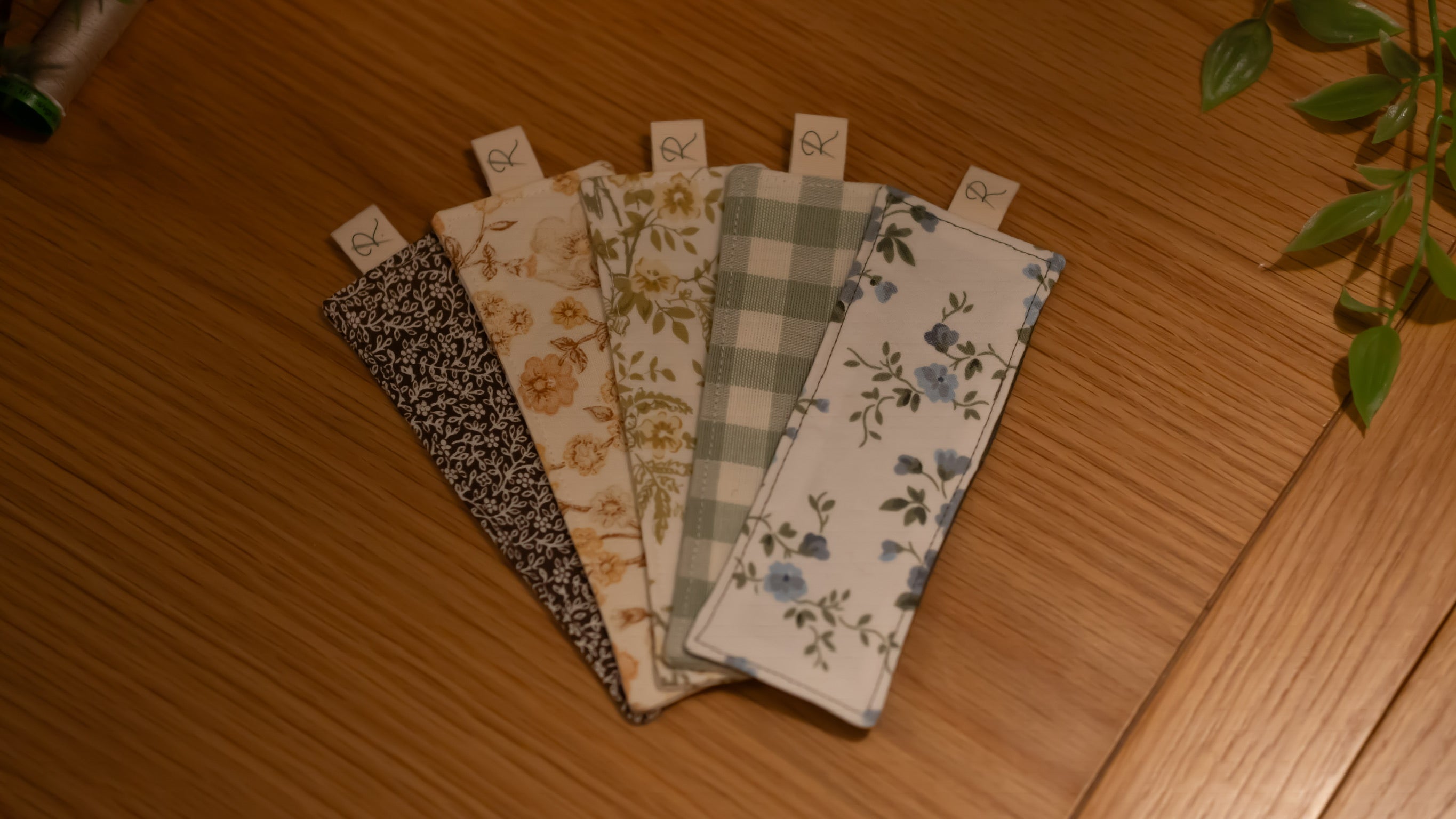 A selection of rectangular fabric bookmarks on a wooden surface