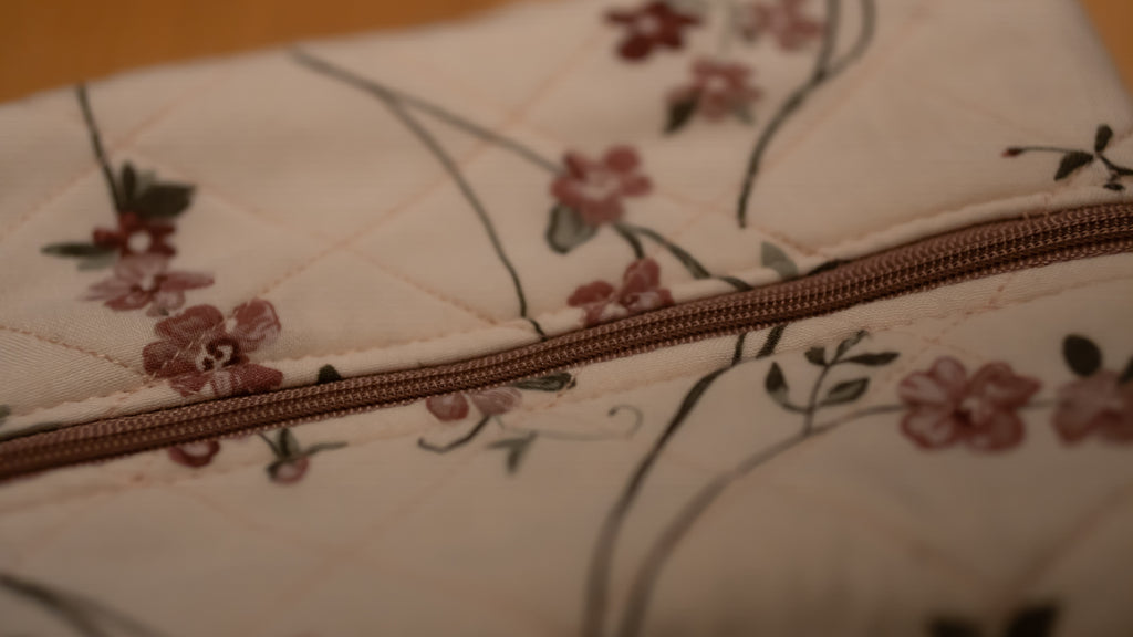 Floral-patterned fabric with a pink zipper running along the middle