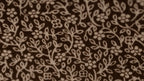 Close-up of brown fabric with subtle floral pattern