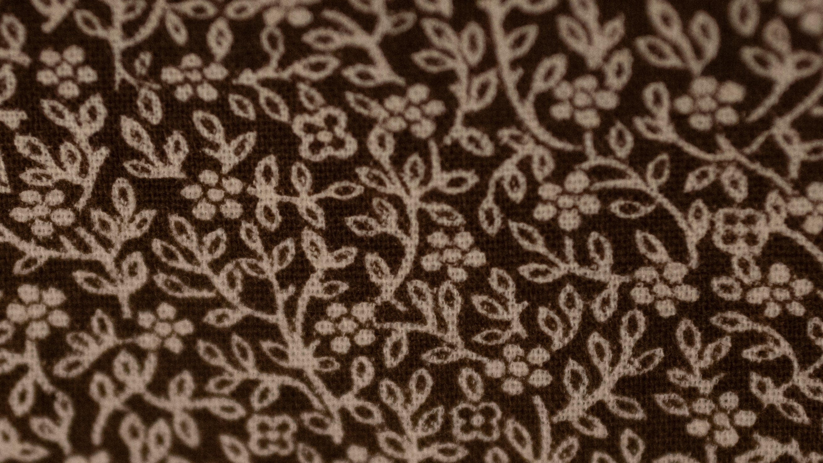 Close-up of brown fabric with subtle floral pattern