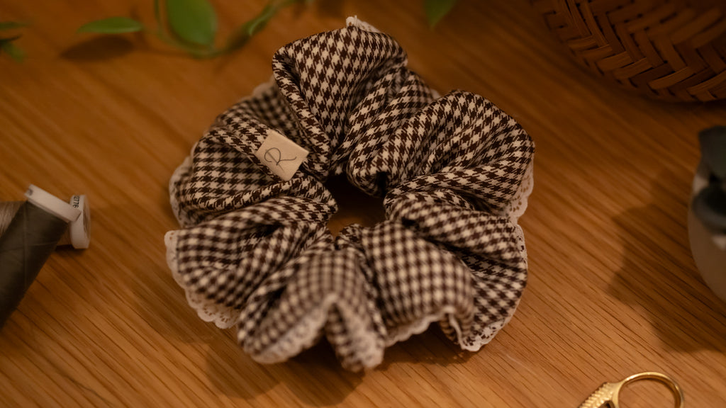 Brown and white checkered scrunchie on a wooden surface