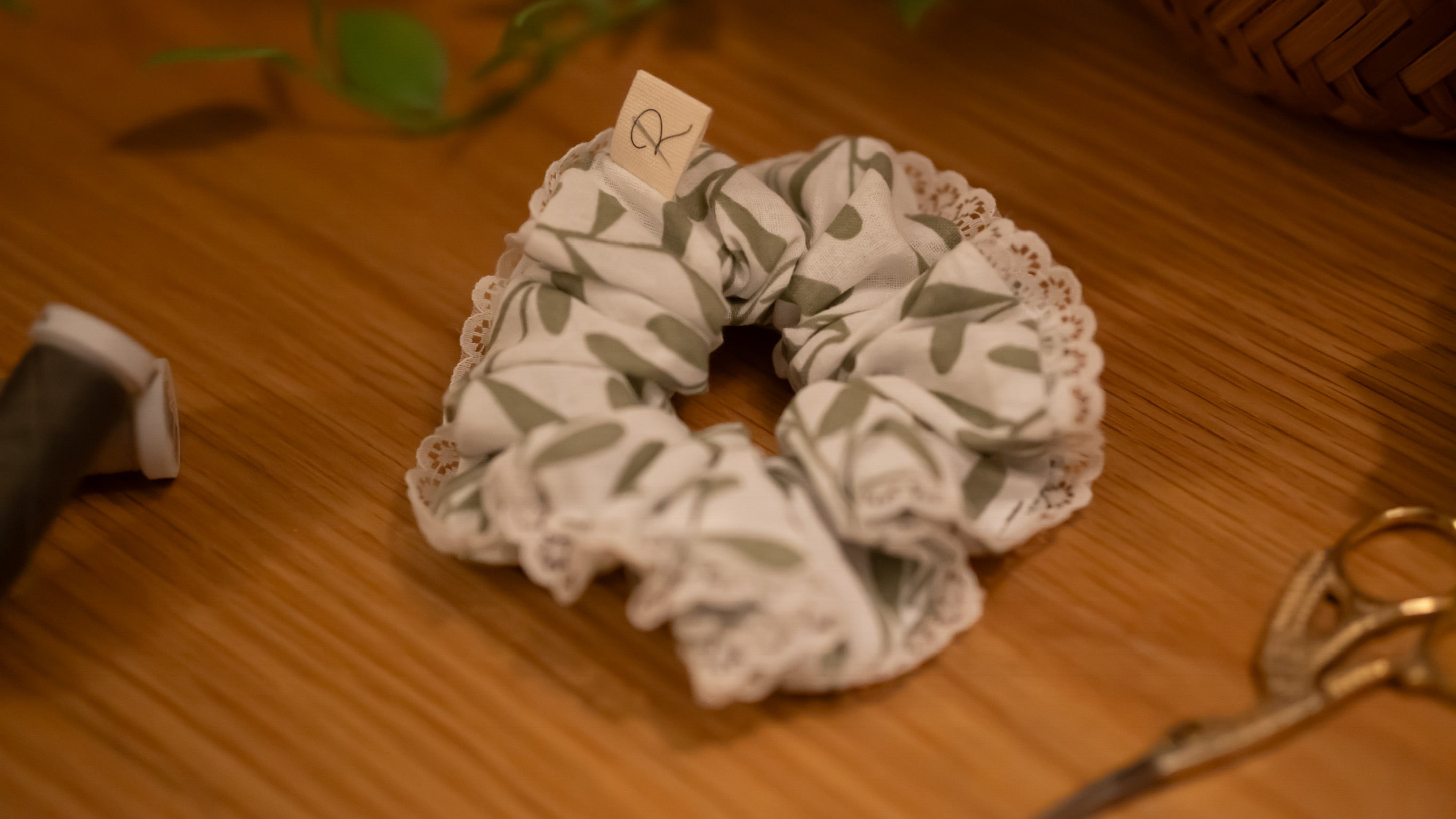 Scrunchie with leaf pattern and lace edge on a wooden surface
