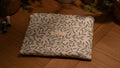 Fabric laptop sleeve with leaf pattern on a wooden surface