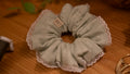 Light green scrunchie with lace edge on a wooden surface