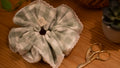 Checkered fabric scrunchie with lace details on a wooden surface with scissors.