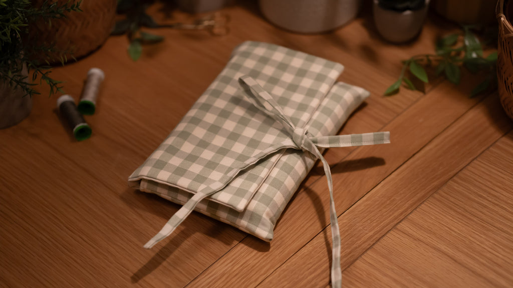 Checkered fabric book sleeve tied with a ribbon on a wooden surface