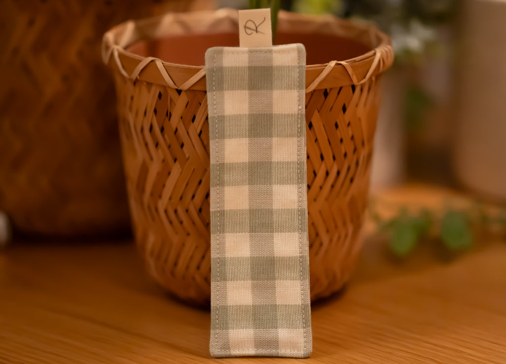 Checkered fabric bookmark with a wooden plant pot in the background