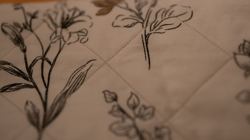 Floral line drawings on a quilted fabric