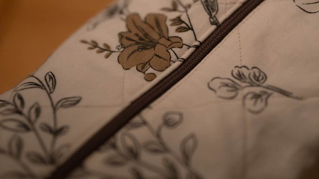Close-up of a floral-patterned fabric with brown and black details and brown zip