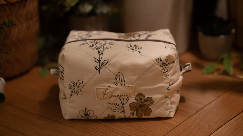 Floral-patterned boxy bag with 'Resewn' branding on a wooden surface
