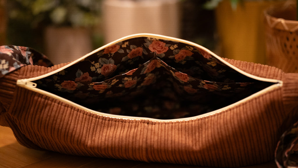 Brown corduroy bag with floral-patterned lining showing pockets